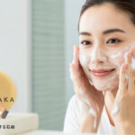 笑顔の女性が泡で洗顔しているシーン。手前に#肌をメイクする石鹸が映っている