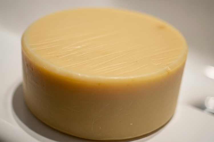 #肌をメイクする石鹸のクローズアップ。ベージュがかった黄色い丸い石鹸で、質感がはっきりわかる。