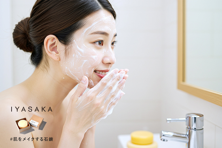 泡で洗顔する女性。背景に#肌をメイクする石鹸が置かれたバスルーム