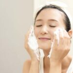 50代女性が笑顔で洗顔し、若々しい肌を保つイメージ。