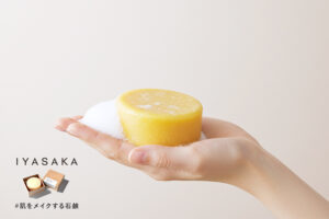 #肌をメイクする石鹸と泡を手に乗せた女性の手