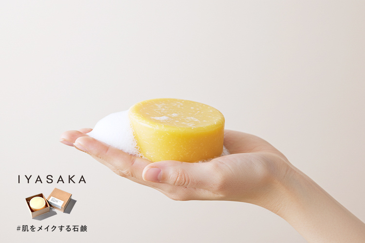 #肌をメイクする石鹸と泡を手に乗せた女性の手