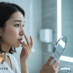 鏡でいちご鼻の黒ずみを確認する女性