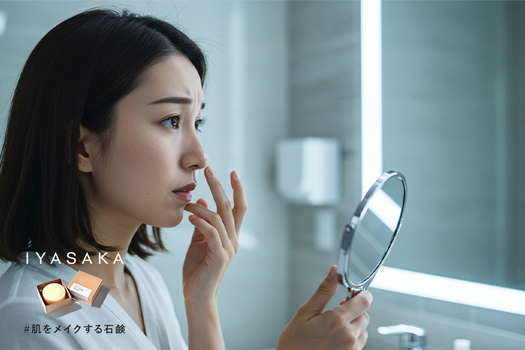 鏡でいちご鼻の黒ずみを確認する女性