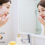 50代女性が泡で洗顔する様子。
