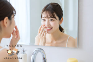 笑顔の女性が鏡で毛穴レス肌を確認するシーン
