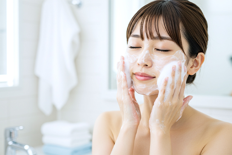 泡立てた洗顔料で優しく洗顔する日本人女性