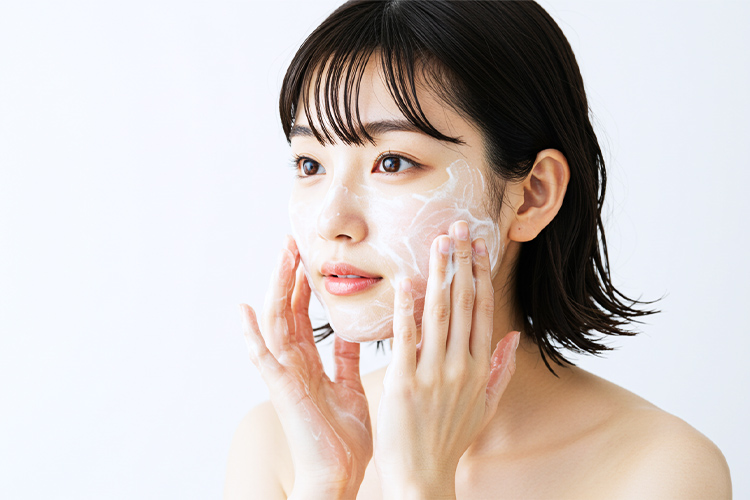 泡で優しく洗顔する女性。指の腹で円を描くように洗う正しい洗顔方法。