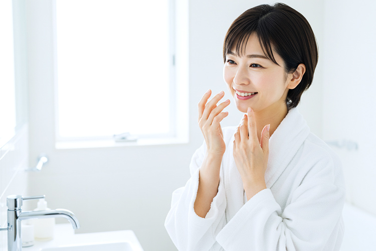 鏡の前で笑顔で肌をチェックする女性