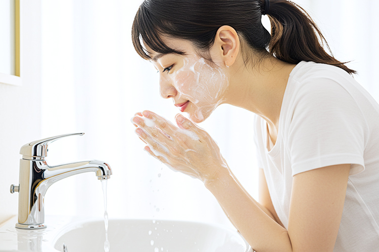 洗顔石鹸の泡で洗顔している女性の写真