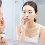 顔のテカリを気にする女性