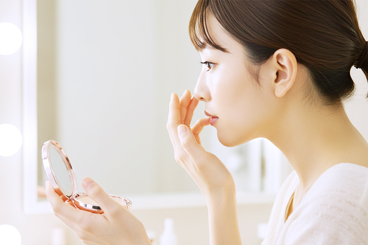 パウダーでテカリを抑える`女性