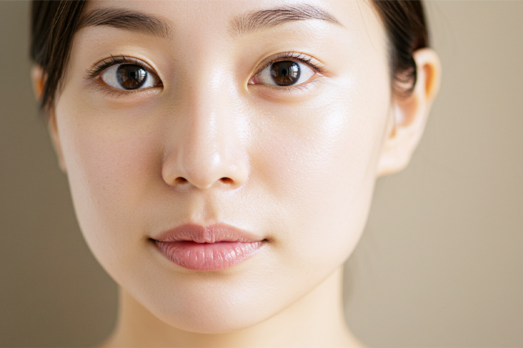 洗顔後の日本人女性の顔のアップ。肌がしっとりとしてツヤがあり、毛穴が引き締まっている