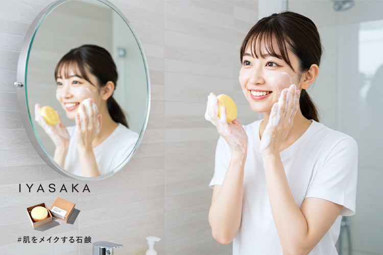 女性が泡立てた洗顔石鹸で笑顔で洗顔しているシーン