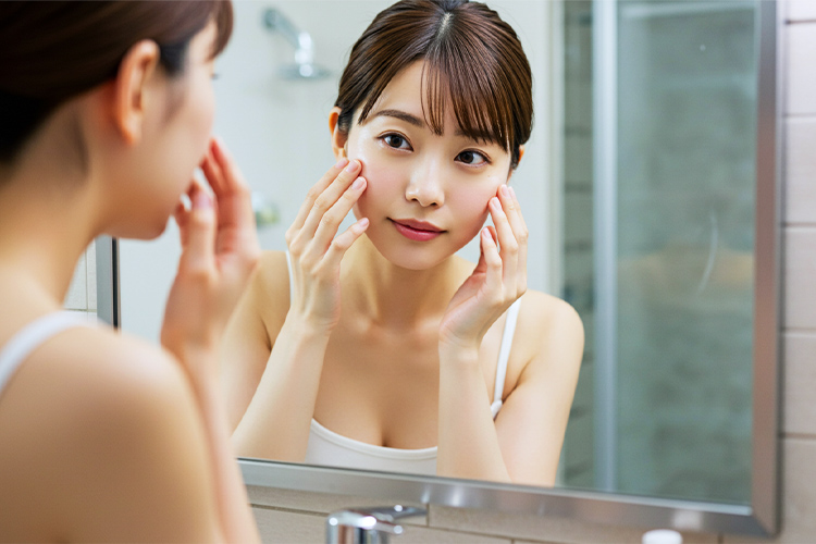 洗顔後のツヤツヤ肌を確認する女性