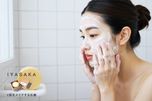 女性が泡で洗顔しているシーン。手前に#肌をメイクする石鹸が映っている。