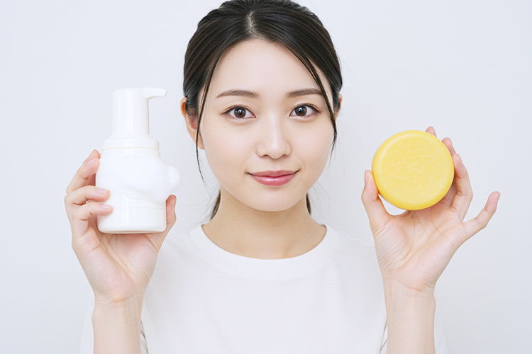 左手には洗顔フォーム、右手には#肌をメイクする石鹸を持っている女性。